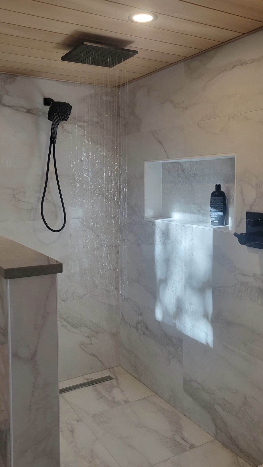 Marble shower with rain head running